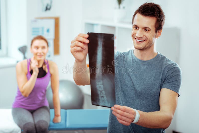 Netter h?bscher Doktor, der ein Bild des Strahls X h?lt lizenzfreies stockfoto Netter h?bscher Doktor, der ein Bild des Strahls X h?lt lizenzfreies stockfoto
