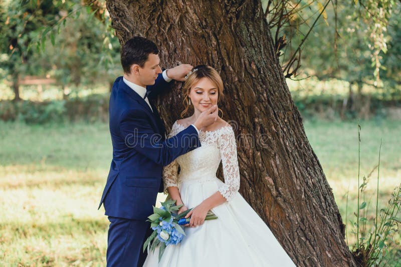 Netter junger und attraktiver Bräutigam, gekleidet in einer strengen modernen stilvollen Klage der blauen Hochzeit, durch Kinn se stockfoto Netter junger und attraktiver Bräutigam, gekleidet in einer strengen modernen stilvollen Klage der blauen Hochzeit, durch Kinn se stockfoto