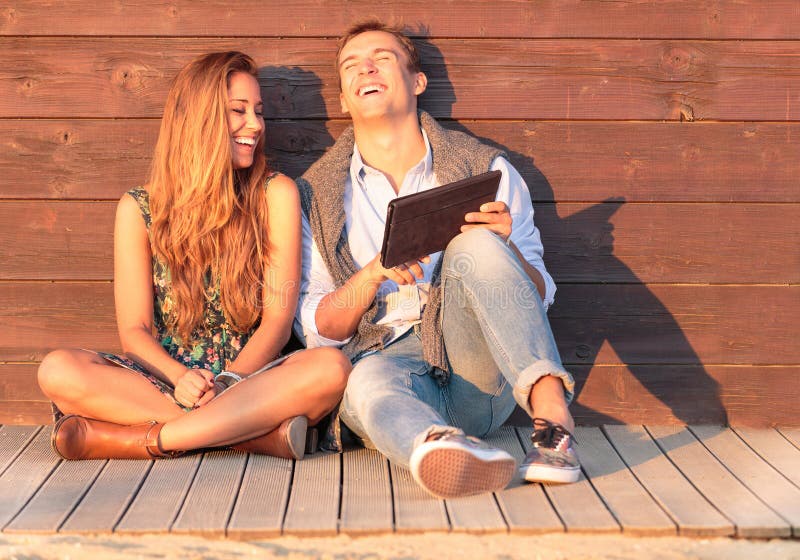 Netter Kerl mit Mädchenlachen über Video auf der Tablette Beste Freunde, die Spaß am Strand mit Social Media und lustigem Inhalt stockfoto Netter Kerl mit Mädchenlachen über Video auf der Tablette Beste Freunde, die Spaß am Strand mit Social Media und lustigem Inhalt stockfoto