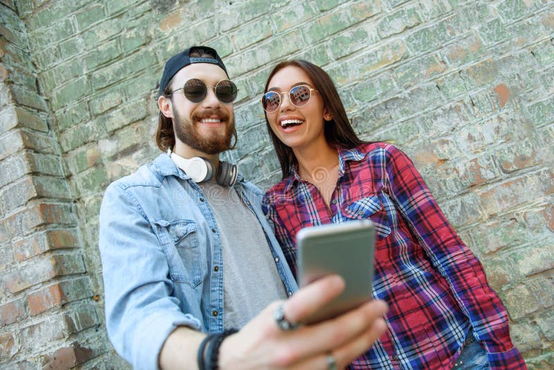Netter Kerl und Mädchen, das Telefon verwendet lizenzfreies stockbild Netter Kerl und Mädchen, das Telefon verwendet lizenzfreies stockbild