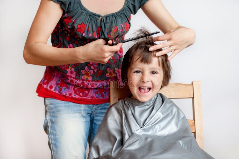 Netter kleiner Junge, den Haarschnitt habend und glücklich lächeln lizenzfreie stockfotografie Netter kleiner Junge, den Haarschnitt habend und glücklich lächeln lizenzfreie stockfotografie