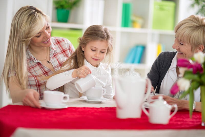 Netter Mädchenumhüllungstee ihre Mutter und Großmutter stockfoto Netter Mädchenumhüllungstee ihre Mutter und Großmutter stockfoto
