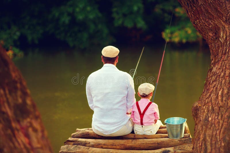 Netter Vater und Sohn, die zusammen unter schöner ursprünglicher Natur fischt