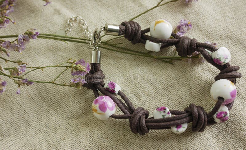 Nettes Frauenarmband auf Gewebe und trockenen Blumen stockfotografie Nettes Frauenarmband auf Gewebe und trockenen Blumen stockfotografie