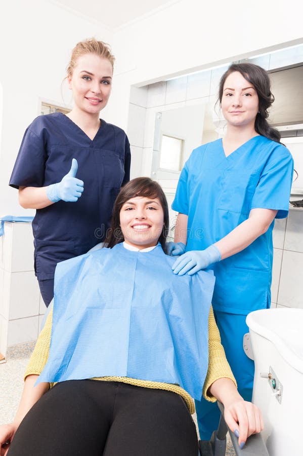 Nettes Frauenzahnarzt thumbup, während Patient und Assistent s sind stockfoto Nettes Frauenzahnarzt thumbup, während Patient und Assistent s sind stockfoto