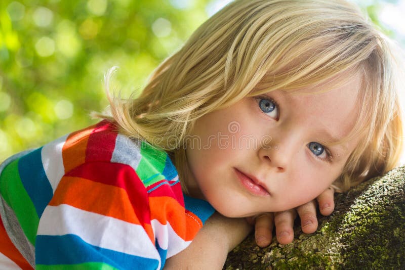 Nettes, glückliches Kind, das sich tief draußen im Gedanken entspannt lizenzfreie stockbilder Nettes, glückliches Kind, das sich tief draußen im Gedanken entspannt lizenzfreie stockbilder