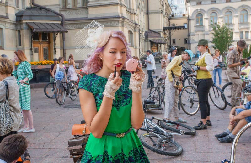 Nettes junges blondes Mädchen in den Weinlesekleidermalereilippen durch Lippenstift in der Menge des Festivals stockfoto Nettes junges blondes Mädchen in den Weinlesekleidermalereilippen durch Lippenstift in der Menge des Festivals stockfoto