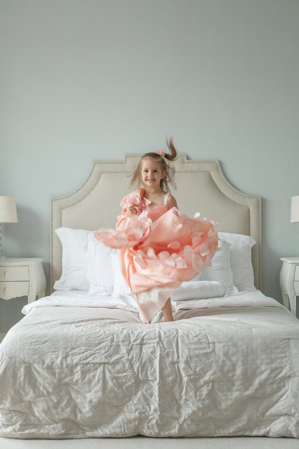 Nettes Kindermädchen, das auf das Bett, Kindheitskonzept springt stockfoto Nettes Kindermädchen, das auf das Bett, Kindheitskonzept springt stockfoto