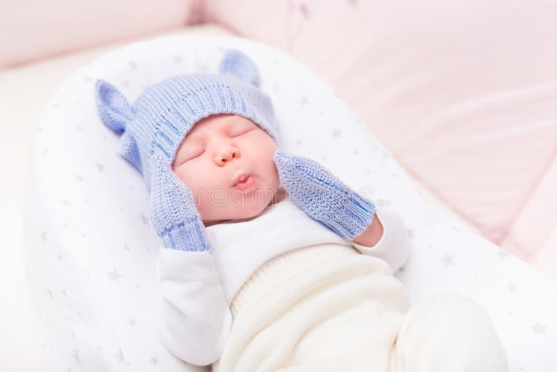 Nettes kleines Baby, das gestrickten blauen Hut mit den Ohren und den Handschuhen trägt stockfotografie Nettes kleines Baby, das gestrickten blauen Hut mit den Ohren und den Handschuhen trägt stockfotografie