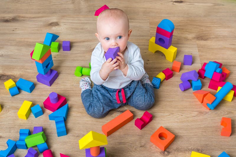 Nettes kleines Baby, das mit bunten Bauklötzen spielt lizenzfreies stockbild Nettes kleines Baby, das mit bunten Bauklötzen spielt lizenzfreies stockbild