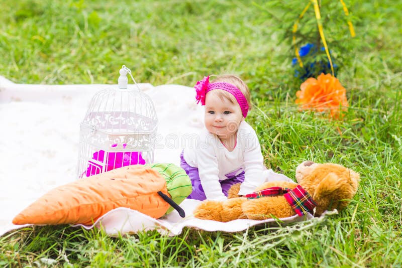 Nettes kleines glückliches Baby mit großem braunem Teddybären betreffen Wiese, Frühling oder Sommersaison des grünen Grases stockfotografie Nettes kleines glückliches Baby mit großem braunem Teddybären betreffen Wiese, Frühling oder Sommersaison des grünen Grases stockfotografie