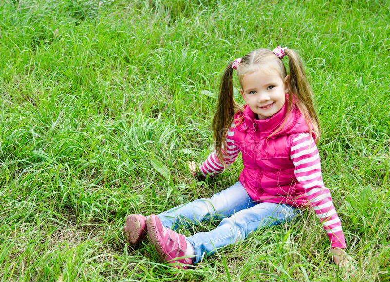 Nettes Lächelndes Kleines Mädchen Das Im Gras Auf Der Wiese Liegt Stockbild Bild Von Gesicht