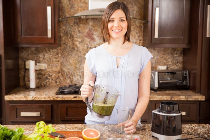 Portrait of a gorgeous young brunette making some healthy juice for breakfast. Portrait of a gorgeous young brunette making some healthy juice for breakfast