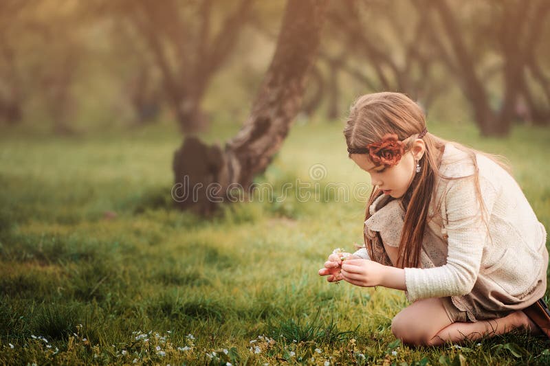 Nettes träumerisches Kindermädchen im beige Ausstattungssammeln blüht im Frühjahr Garten stockbilder Nettes träumerisches Kindermädchen im beige Ausstattungssammeln blüht im Frühjahr Garten stockbilder