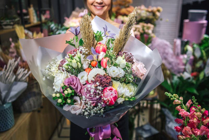 Nettes und buntes bouqette von verschiedenen Blumen Weiblicher Florist halten es und lächeln Sie ist im Blumenladen Schneiden Sie lizenzfreie stockfotos Nettes und buntes bouqette von verschiedenen Blumen Weiblicher Florist halten es und lächeln Sie ist im Blumenladen Schneiden Sie lizenzfreie stockfotos