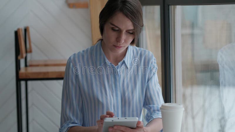 Nettes weibliches Sitzen in der Cafeteria und Anwendung der digitalen Tablette