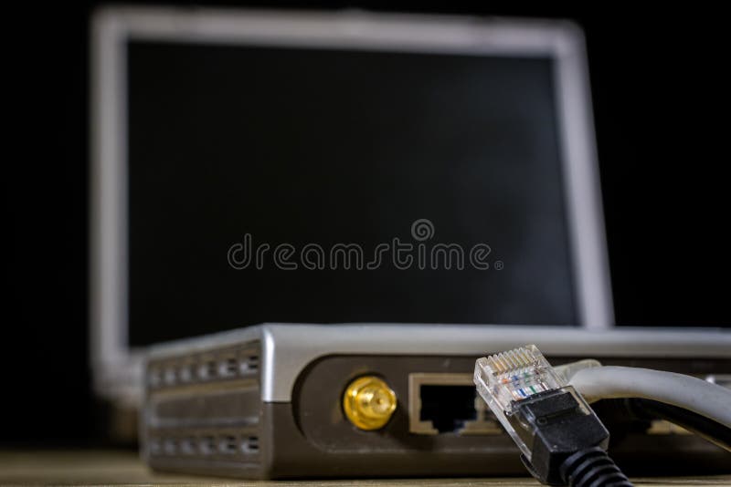 Network hub and rj45 cables on the stage. Computer accessories used in networking. Black background.