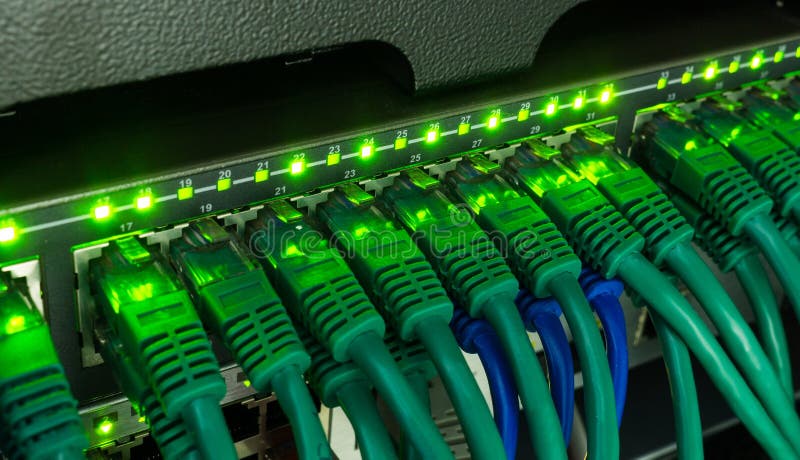 Network switch and ethernet cables glowing in server room royalty free stock photography