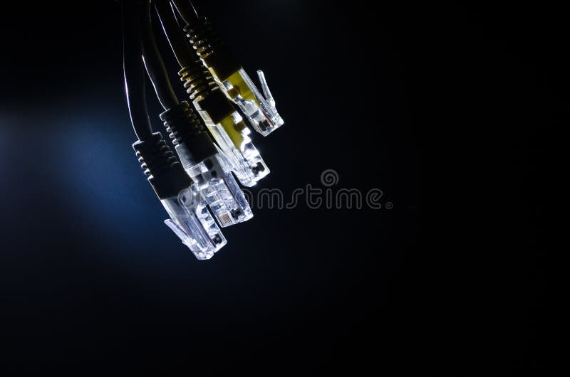 Network switch and ethernet cables, symbol of global communications. Colored network cables on dark background with lights and smo