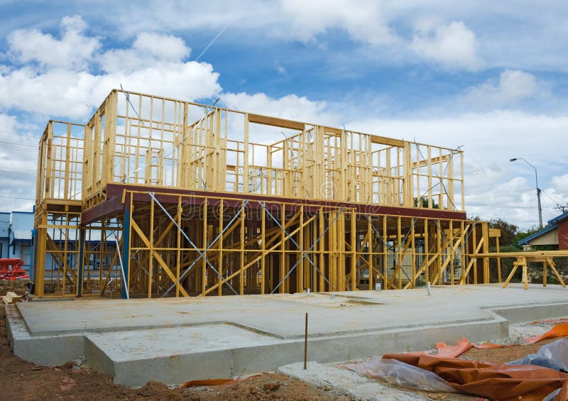 New residential construction home framing against a blue sky. New residential construction home framing against a blue sky.