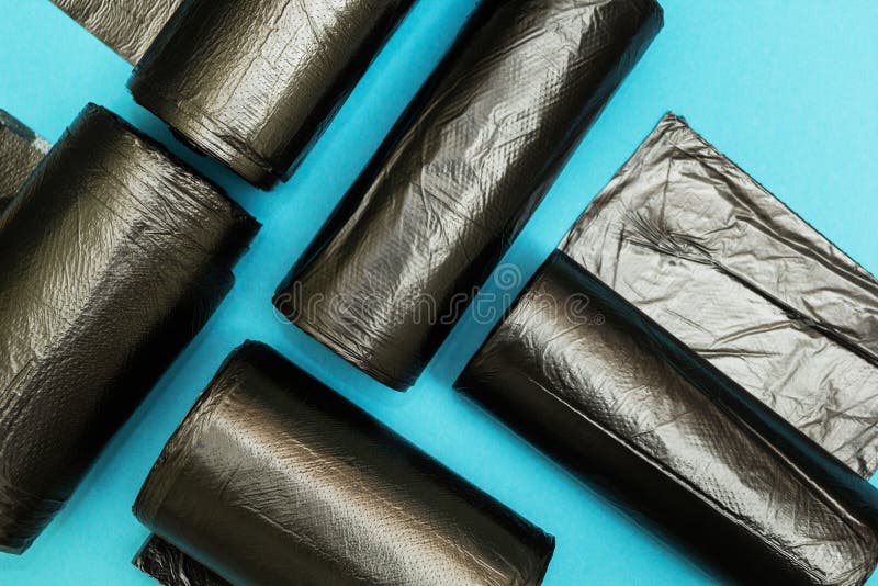 Neue schwarze Abfalltaschen auf einem blauen Hintergrund lizenzfreie stockfotografie Neue schwarze Abfalltaschen auf einem blauen Hintergrund lizenzfreie stockfotografie