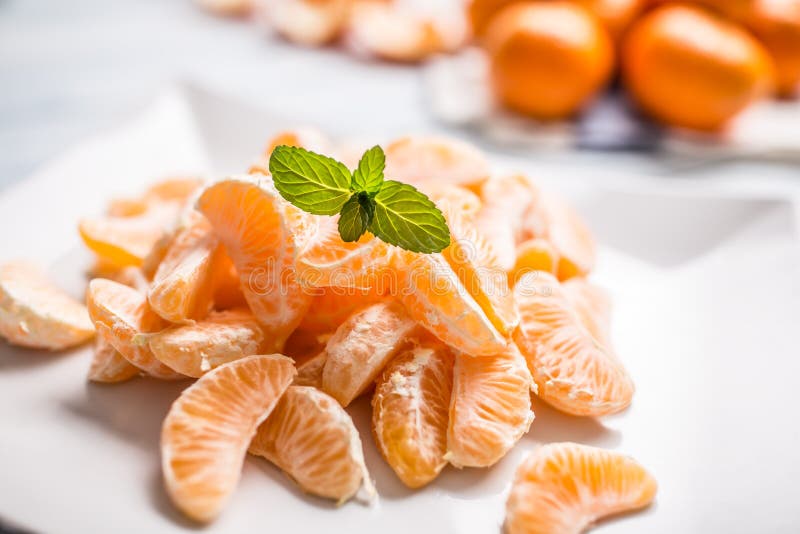 Neue Stücke der Tangerinemandarine auf der Platte oder in einer Schüssel lizenzfreie stockfotografie Neue Stücke der Tangerinemandarine auf der Platte oder in einer Schüssel lizenzfreie stockfotografie