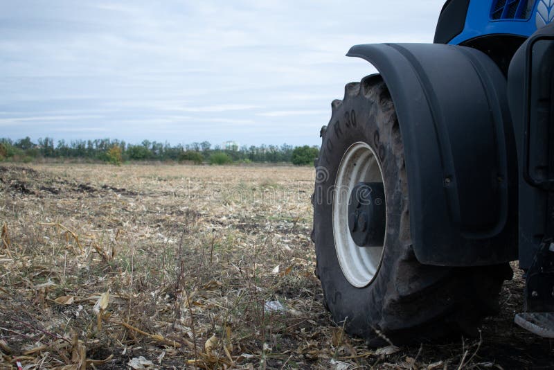 New blue tractor Holland wheel at demonstration field site at agro exhibition AgroExpo. Tractor working on the farm, modern agricultural transport. Kropivnitskiy, Ukraine, September 27, 2018, agriculture, farmer, farming, arable, car, cloud, clouds, crop, dust, earth, equipment, gleam, harvest, headlights, horizontal, large, logistics, market, mirror, preparation, ranch, ride, rural, sale, service, shine, sky, space, steel, technologically, tire, trailer, transportation, tread, vehicle. New blue tractor Holland wheel at demonstration field site at agro exhibition AgroExpo. Tractor working on the farm, modern agricultural transport. Kropivnitskiy, Ukraine, September 27, 2018, agriculture, farmer, farming, arable, car, cloud, clouds, crop, dust, earth, equipment, gleam, harvest, headlights, horizontal, large, logistics, market, mirror, preparation, ranch, ride, rural, sale, service, shine, sky, space, steel, technologically, tire, trailer, transportation, tread, vehicle