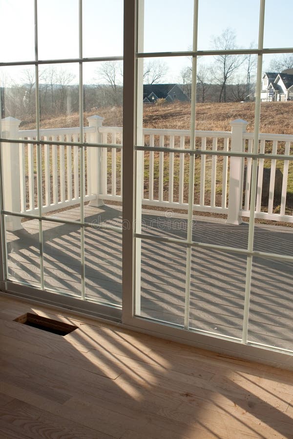 Modern home interior with sliding glass doors leading to a small porch. Modern home interior with sliding glass doors leading to a small porch.