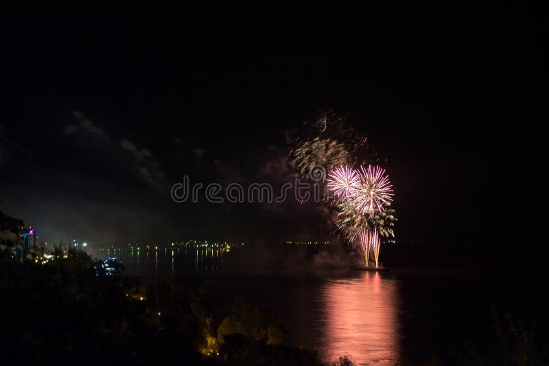 Neues Jahr ` s Eve Fireworks startete vom Wasser mit Reflexionen stockfotografie Neues Jahr ` s Eve Fireworks startete vom Wasser mit Reflexionen stockfotografie
