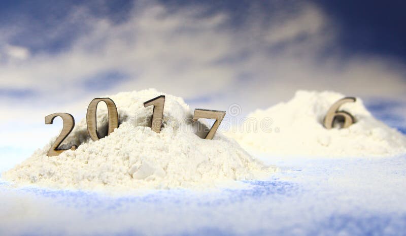 Snowdrift in the forest with figures of the coming new year 2017 against the background of snowfall and fir-trees. Snowdrift in the forest with figures of the coming new year 2017 against the background of snowfall and fir-trees