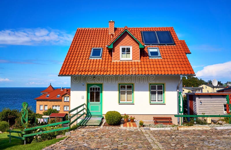 Neues modernes Einfamilienhaus mit roten Dachziegeln und Sonnenkollektoren Leben auf der Insel Rügen mit Blick auf die Ostsee lizenzfreies stockbild Neues modernes Einfamilienhaus mit roten Dachziegeln und Sonnenkollektoren Leben auf der Insel Rügen mit Blick auf die Ostsee lizenzfreies stockbild