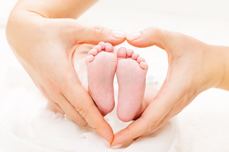 Neugeborene Baby-Füße in den Mutter-Händen Herz, Mutter und neugeborener Kinderfuß