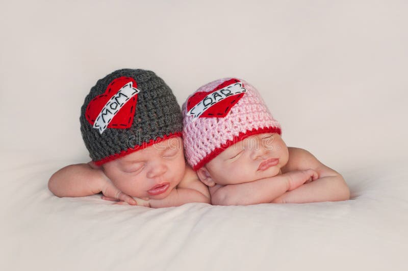 Neugeborene Baby-Zwillinge in den Liebes-Mutter-und Vati-Hüten