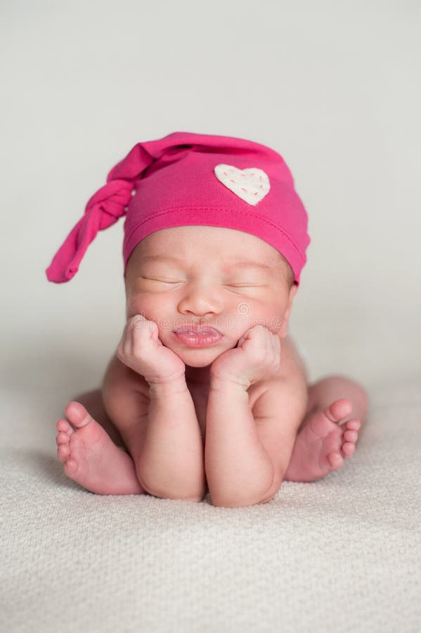 Neugeborenes Baby, das eine rosa Spitzenknoten-Kappe trägt