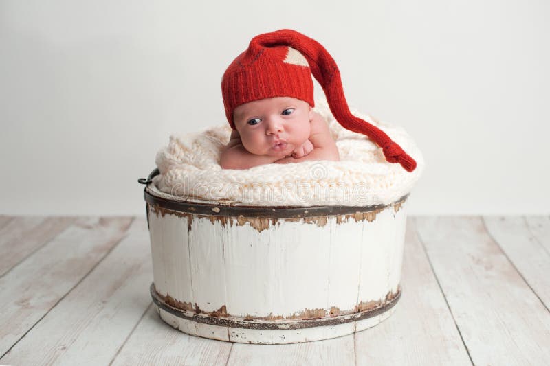 Neugeborenes Baby, das eine rote Strumpf-Kappe trägt