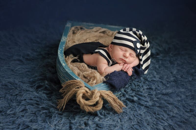 Neugeborenes Baby, das in einem Boot schläft stockfotografie Neugeborenes Baby, das in einem Boot schläft stockfotografie