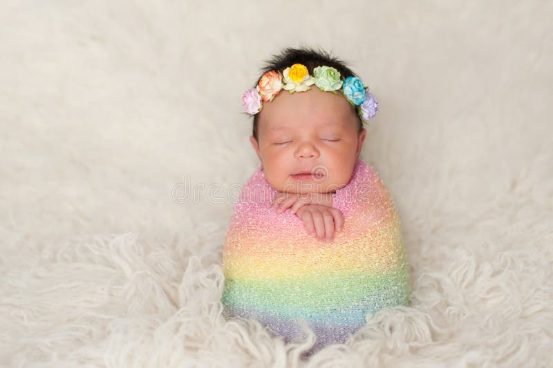 Neugeborenes Baby mit dem gefärbten Regenbogen wickeln