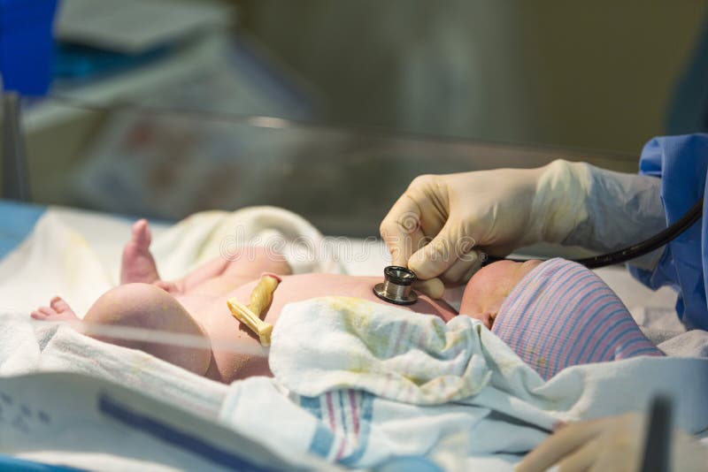 Neugeborenes männliches Baby, das mit Stethoskop überprüft wird
