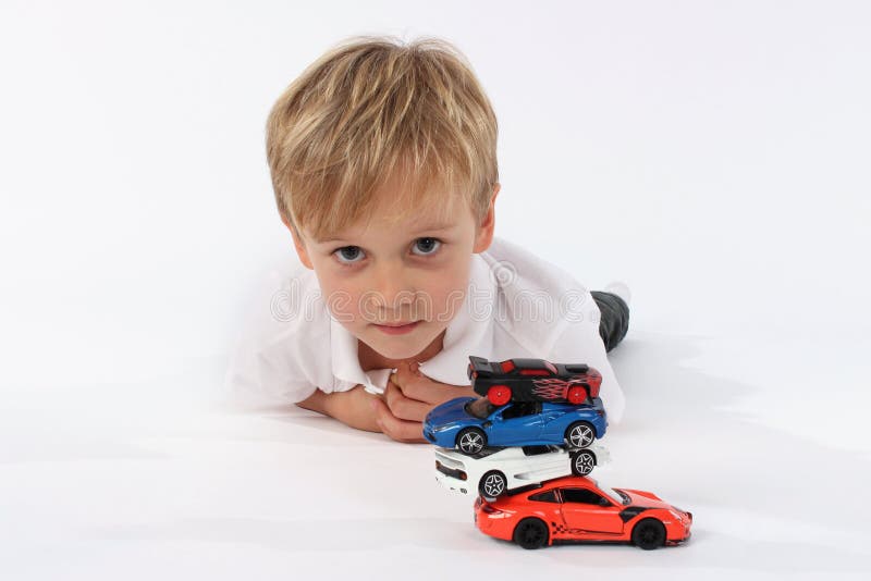 Neutraal en onschuldig kijk van een kleuterschoolkind na het spelen met een autospeelgoed royalty-vrije stock afbeeldingen Neutraal en onschuldig kijk van een kleuterschoolkind na het spelen met een autospeelgoed royalty-vrije stock afbeeldingen