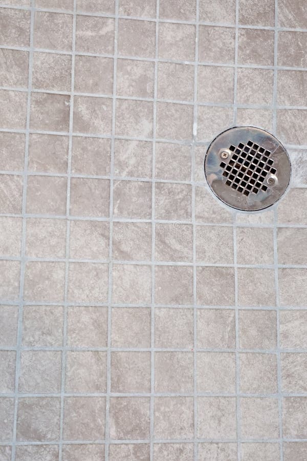 A Neutral Light Beige Square Tile Shower Floor with a Silver Metal