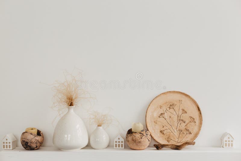 Neutrale Vasen auf einem weißen Regal gegen grobes Stuck einer grauen Wand Inneneinrichtung