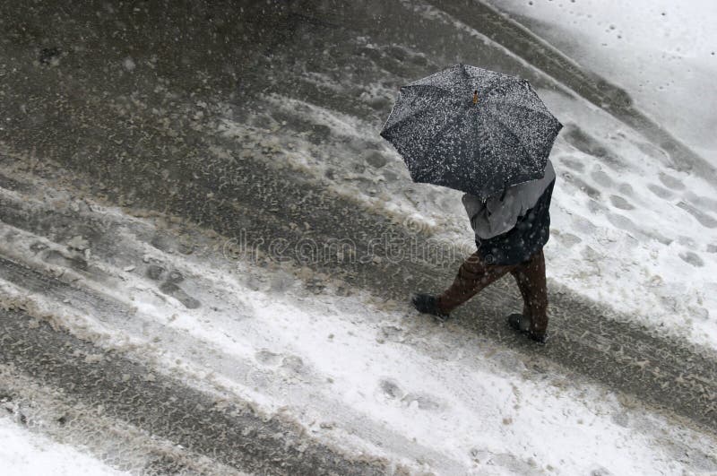 Adult walking through city during snowstorm. Adult walking through city during snowstorm