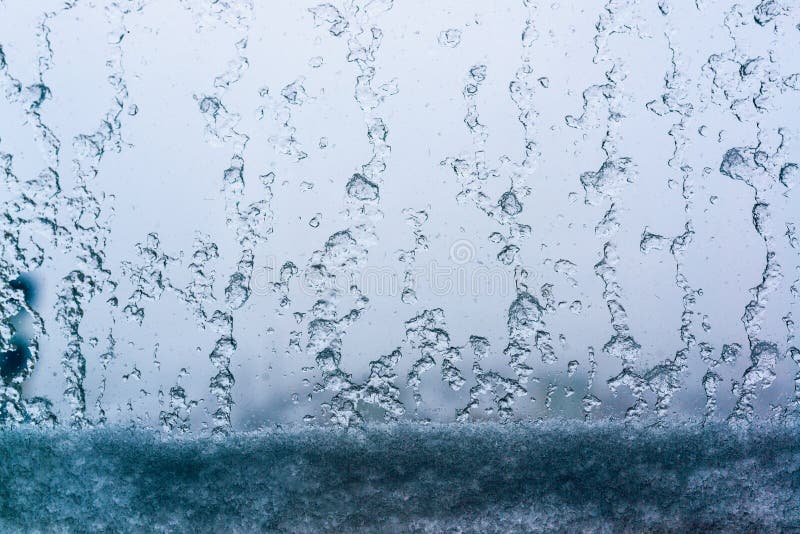 Neve e gocce di acqua sul vetro di finestra fotografia stock libera da diritti Neve e gocce di acqua sul vetro di finestra fotografia stock libera da diritti