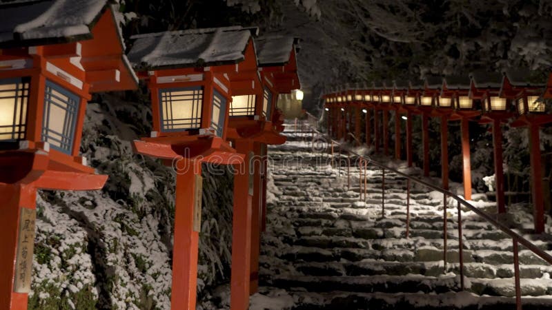 Neve no japão de kyoto. kifune encolhe polo de luz tradicional na noite de inverno de neve. guarda-chuva japonês nas escadas de pe