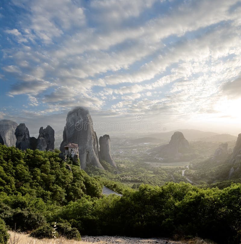 Nevelig bij zonsondergang op rotsen van Meteora, Griekenland stock afbeelding Nevelig bij zonsondergang op rotsen van Meteora, Griekenland stock afbeelding