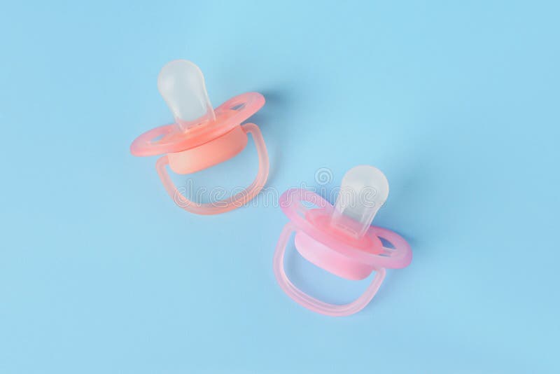 New Baby Pacifiers on Light Blue Background, Flat Lay Stock Photo