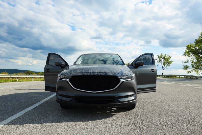 New Black Modern Car with Open Doors on Asphalt Road Stock Image