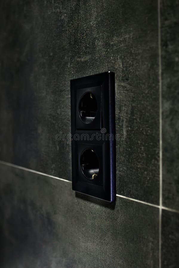 New Black Rosette on a Ceramic Tile of Black Color. Electrical Outlet. Bathroom. Stock Image