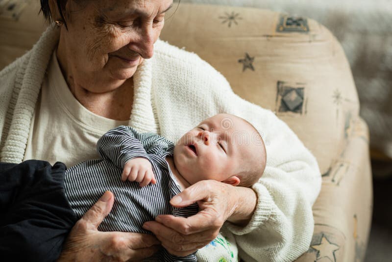 New born baby and his grandmother together. stock photos New born baby and his grandmother together. stock photos