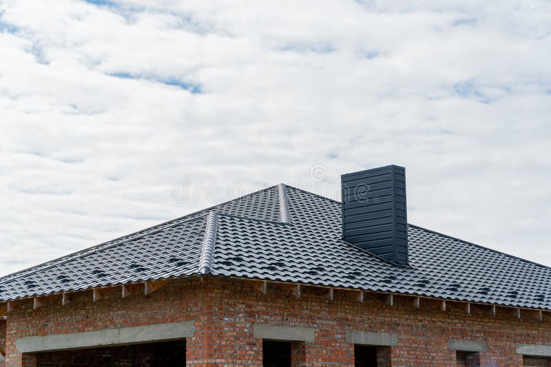 A New Brick House with a Black Roof. Construction of a House Stock